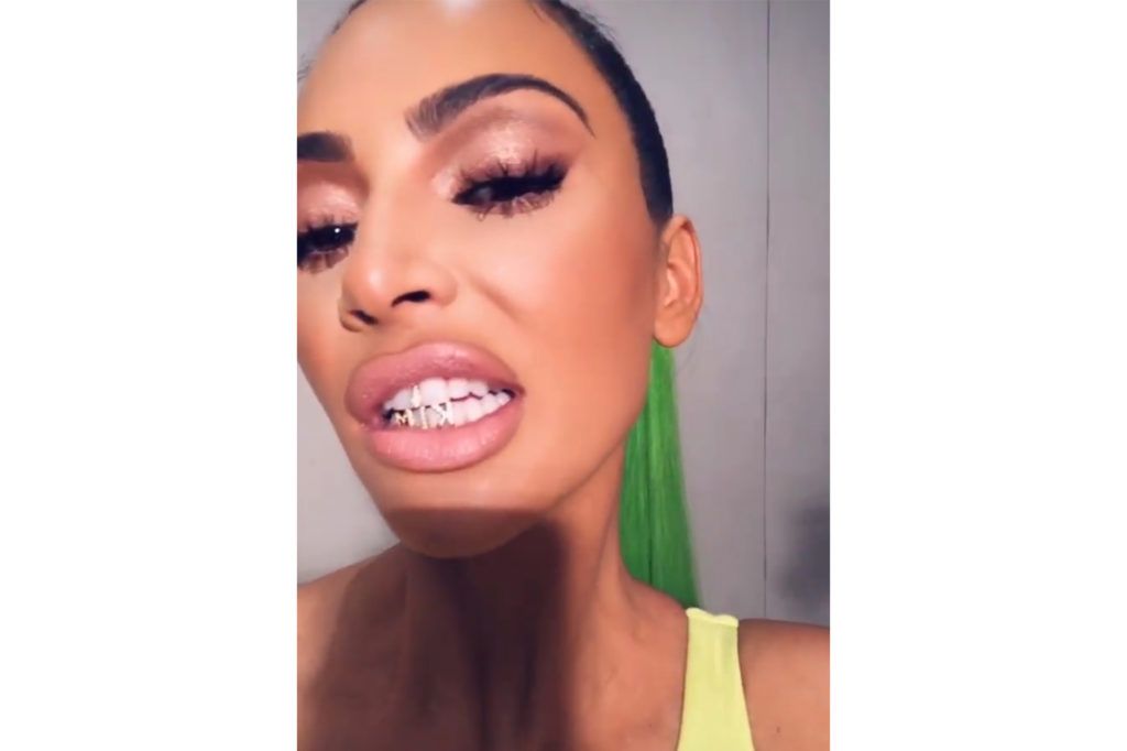 Kim Kardashian muestra su nuevo ‘grillz’ mientras deslumbra sus dientes con diamantes y una pequeña cruz